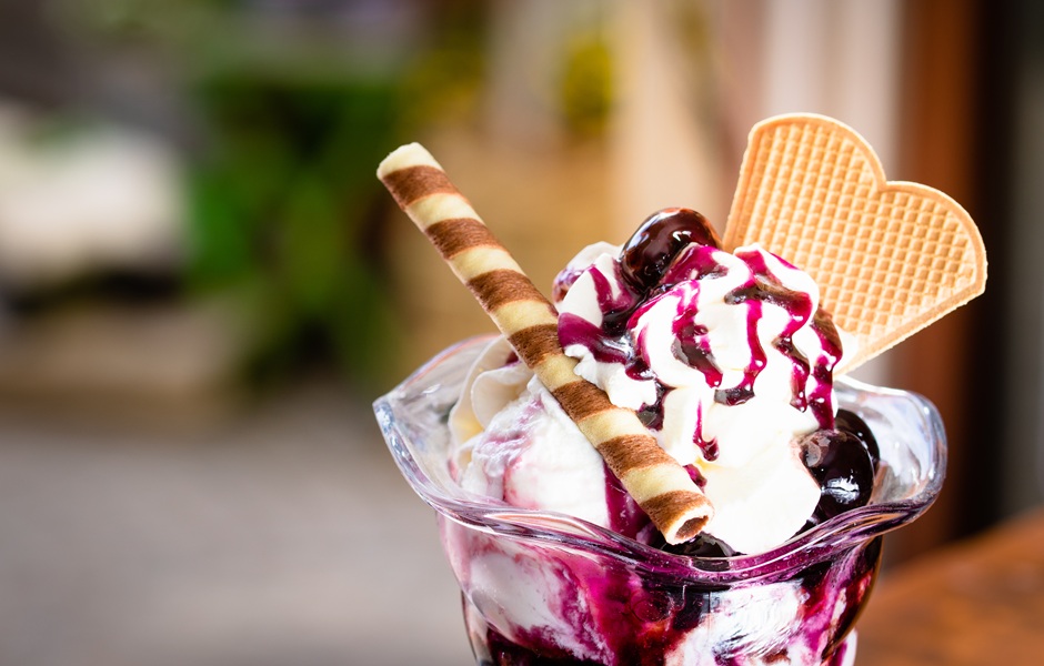 Sorvete de Flocos com calda de cereja, chantilly, wafer e biscoito de coração em copo de sobremesa, ideal para sobremesas e acompanhamentos doce.