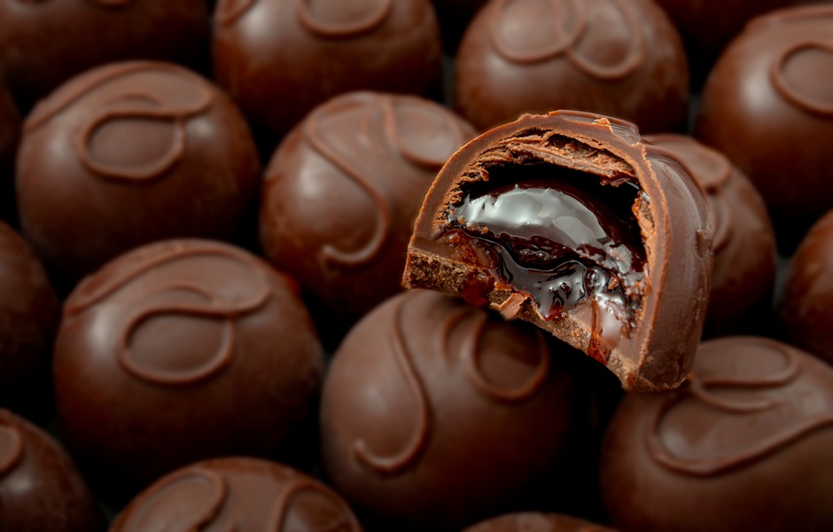 Imagem de diversas napolitanas de chocolate com uma napolitana cortada ao meio, mostrando recheio de brigadeiro, leite condensado e creme de avelã, ideal para quem busca doces gourmet para festas e eventos.